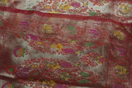 view of a red and gold ornate Indian saree, showcasing its detailed embroidery.